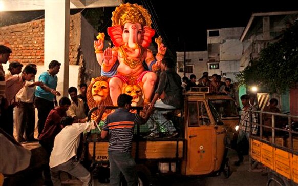 अहमदाबाद में भगवान गणेश की प्रतिमा को पूजा के लिए ले जाते श्रद्धालु।