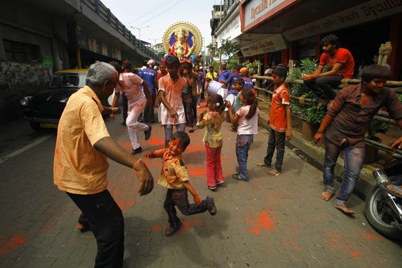 मुंबई में गणेश चतुर्थी त्योहार के दौरान हिंदू श्रद्धालु डांस करते हुए।