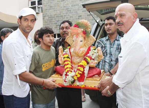 भगवान गणेश की प्रतिमा को घर लाते हुए अभिनेता राकेश रोशन और रितिक रोशन।