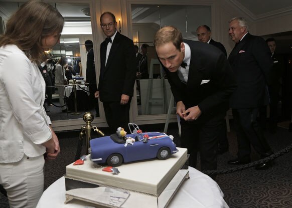 ब्रिटेन के राजकुमार प्रिंस विलियम्स एक वेडिंक केक को देखते हुए।