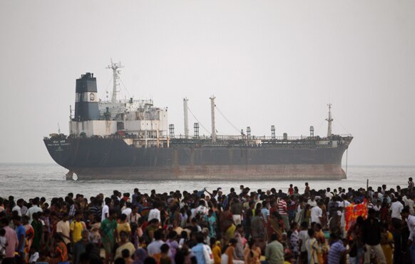 चेन्नई के समुद्री तट पर फंसे प्रतिभा कावेरी जहाज को देखते लोग।