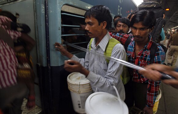 छठ पूजा के अवसर पर नई दिल्ली से बिहार जाने वाली ट्रेन में चढ़ते यात्री।