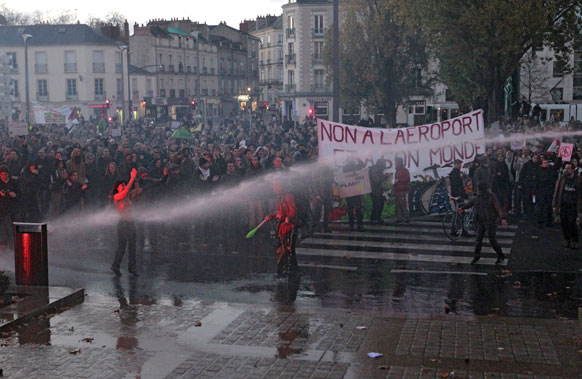 फ्रांस के पश्चिम हिस्से में प्रदर्शनकारियों को तितर-बितर करने के लिए पानी की बौछार करती पुलिस।
