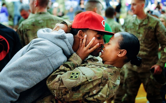 अफगानिस्तान में तैनाती से लौटने के बाद कोलोराडो स्प्रिंग में अपनी प्रेमिका को चूमता एक सैनिक।