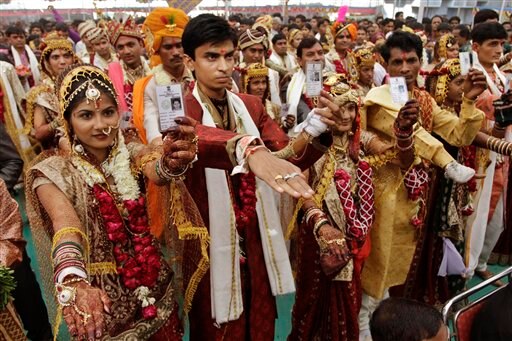 गुजरात : अहमदाबाद में एक सामूहिक शादी के मौके पर अपने हाथों में मतदाता पहचान पत्रों को थामकर आगामी विधानसभा चुनाव में वोट डालने की अपील करते हुए नविवाहित जोड़े। पहले चरण की वोटिंग 13 दिसंबर को है।