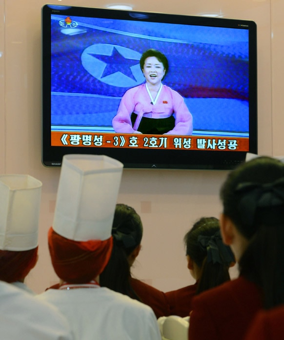 उत्तर कोरिया के प्योंगयांग में टीवी देखेते रेस्टोरेंट के कर्मचारी।