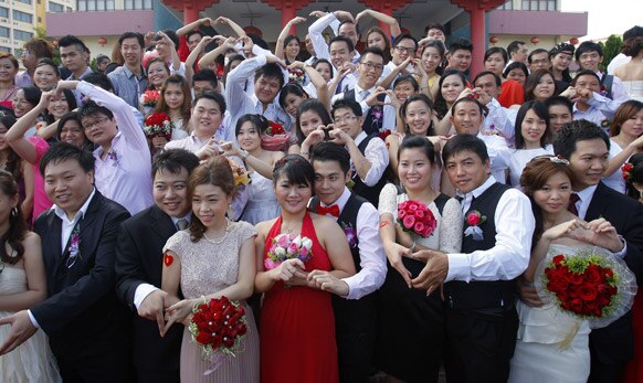 मलेशिया के कुआलालांपुर में सामूहिक विवाह समारोह में फोटो सेशन के दौरान कपल्स।