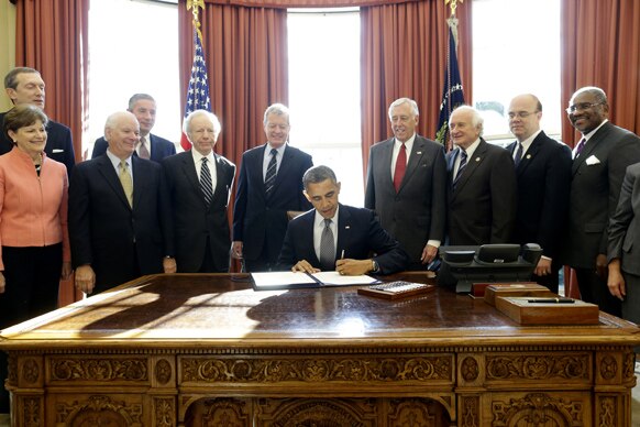 ह्वाइट हाउस में एक करार पर हस्ताक्षर करते अमेरिकी राष्ट्रपति बराक ओबामा।