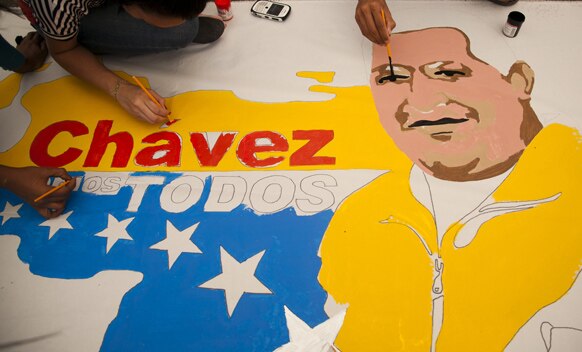 वेनेजुएला के काराकस में राष्ट्रपति ह्यूगो शावेज की तस्वीर बनाते उनके समर्थक।