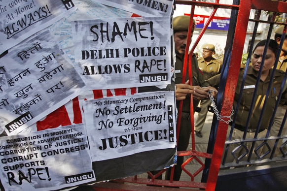 नई दिल्ली में गैंग रेप के विरोध में प्रदर्शन के दौरान पुलिसकर्मी थाने का गेट बंद करते हुए।