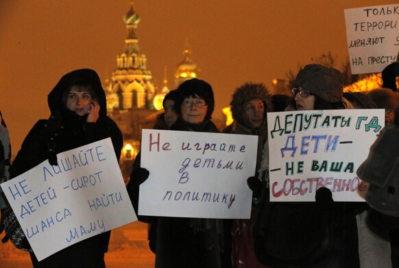 रूस के सेंट पीट्सबर्ग में बच्‍चों के गोद लेने के अधिकार के समर्थन प्रदर्शन करती हुईं विपक्षी कार्यकर्ताएं।
