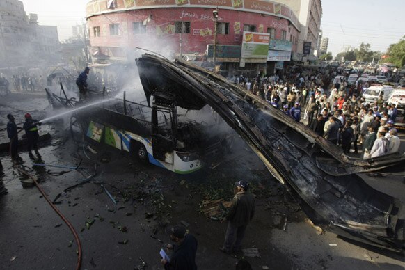 कराची में एक धमाके के बाद फैले आग को बुझाते हुए पाकिस्‍तानी दमकलकर्मी।
