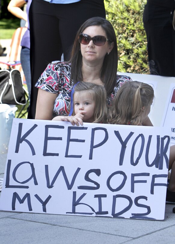 कैलिफ में अपने बच्चे के साथ एक रैली में शरीक होती महिला।