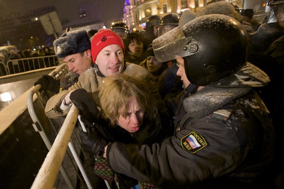 मास्को में रूसी पुलिस प्रदर्शनकारियों को रोकने की कोशिश करती हुई।