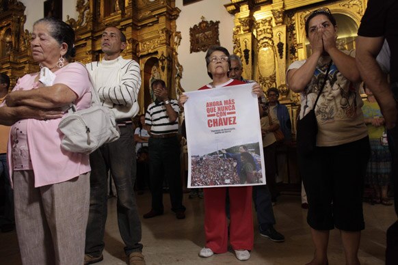 वेनेजुएला में एक चर्च के बाहर प्रदर्शन करते लोग।