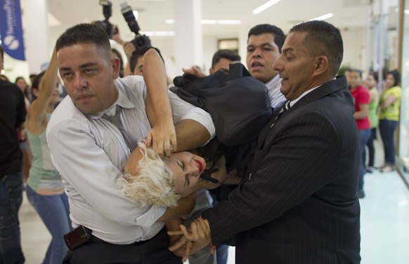 FEMEN समूह के एक व्यक्ति को ब्राजील के सुरक्षा कर्मी हटाते हुए।