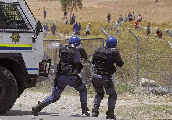 दक्षिण अफ्रीका में किसानों पर रबर फायरिंग करते पुलिसकर्मी।