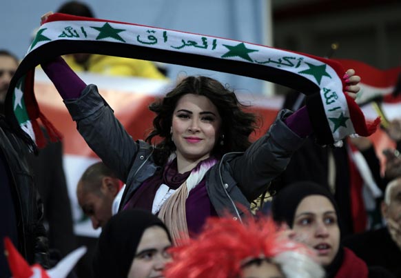 बहरीन में फुटबॉल टूर्नामेंट के दौरान अपने देश का झंडा लहराती एक महिला।