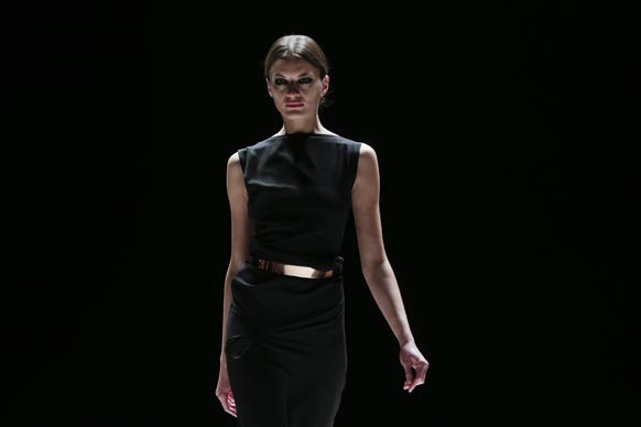 बर्लिन में मर्सिडीज बेंज फैशन वीक के दौरान डिजायन कपड़ों को पेश करती एक मॉडल।
