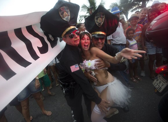 ब्राजील के रियो डि जेनेरो में प्री कार्निवल पेरेड के दौरान फोटो पोज देते प्रतिभागी।