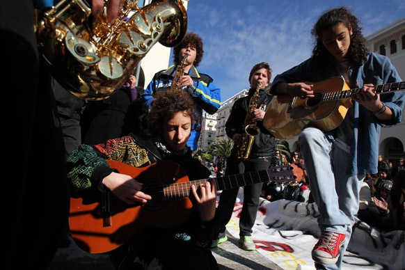 उत्‍तरी ग्रीक पोर्ट सिटी थेसालोनिकी में एक विरोध प्रदर्शन के दौरान छात्र गीत-संगीत में खोये हुए।