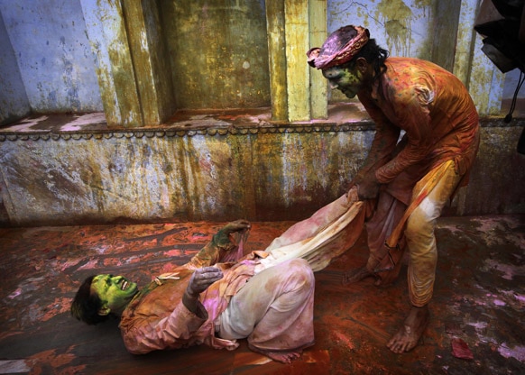 राधा-कृष्ण के नंदग्राम मंदिर में होली खेलते दो युवक।