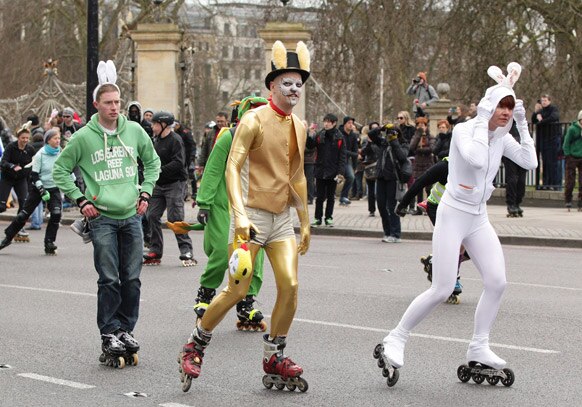 ईस्टर के मौके पर खरगोश के कपड़े पहनकर लंदन की सड़कों पर स्केटिंग करते लोग।