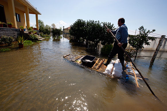 तिराना के 120 किलोमीटर दूर शकोडर शहर में आई बाढ़ से बेहाल लोग।