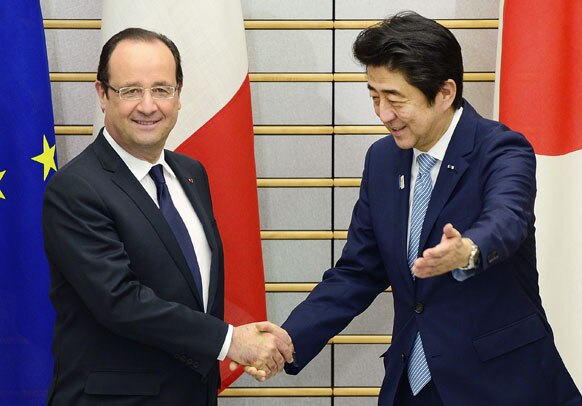 टोक्यो में जापान के प्रधानमंत्री शिंजो एबे से हाथ मिलाते फ्रांस के राष्ट्रपति फ्रैंकोइस होलांद।