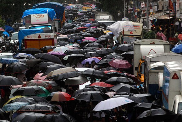 मुंबई में भारी बारिश के चलते एक रेलवे स्टेशन के बाहर लोगों का जमावड़ा।