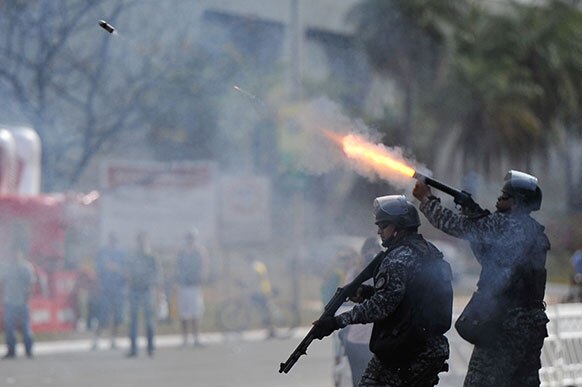 ब्राजीलिया में प्रदर्शनकारियों पर रबड़ की गोली दागता एक पुलिसकर्मी।