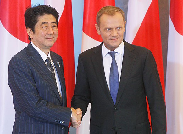 पोलैंड के वर्सा में बैठक से पहले अपने समकक्ष डोनाल्ड टस्क के साथ हाथ मिलाते जापान के प्रधानमंत्री शिंजो एबे।