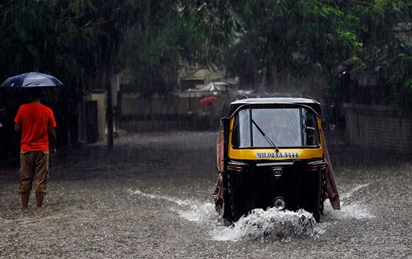 मुंबई में भारी बारिश के चलते सड़क पर जगह-जगह पानी जमा हो गया है।