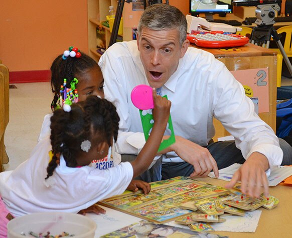 सेंट बेनेडिक्ट सेंटर में बच्चों के साथ अमेरिकी शिक्षा मंत्री अर्ने डंकन।