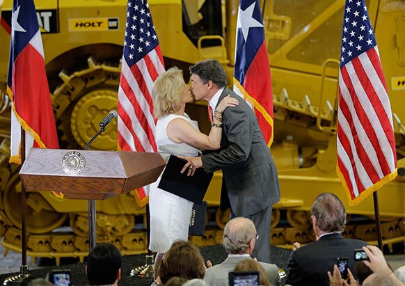 अमेरिका में टेक्सास के गवर्नर रिक पेरी अपनी पत्नी को एक समारोह में खुशी से चूमते हुए।