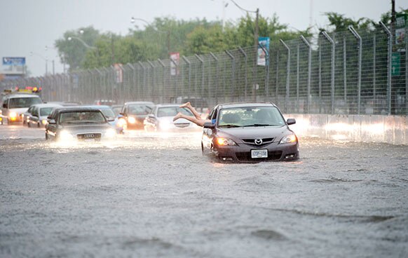 टोरंटो में आई बाढ़ में कई गाड़ियां कुछ यूं फंस गई।