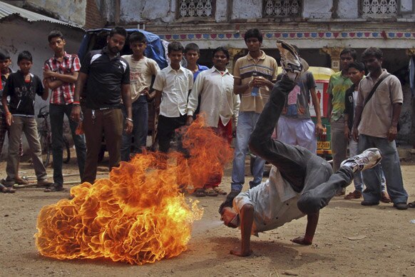 अहमदाबाद में भगवान जगनन्नाथ की रथयात्रा के दौरान आग के साथ स्टंट दिखाता युवक।