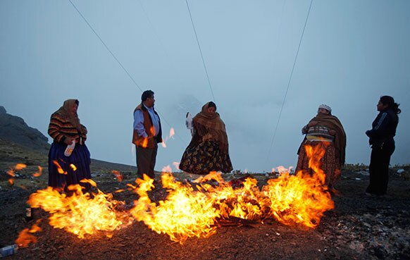 बोलीविया में आग जलाकर कुछ रस्मों को अंजाम देते लोग।