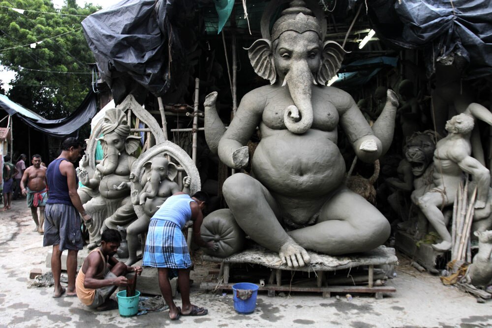 गणेश चतुर्दशी के लिए कोलकाता में भगवान गणेश की मूर्ति तैयार करते कलाकार।
