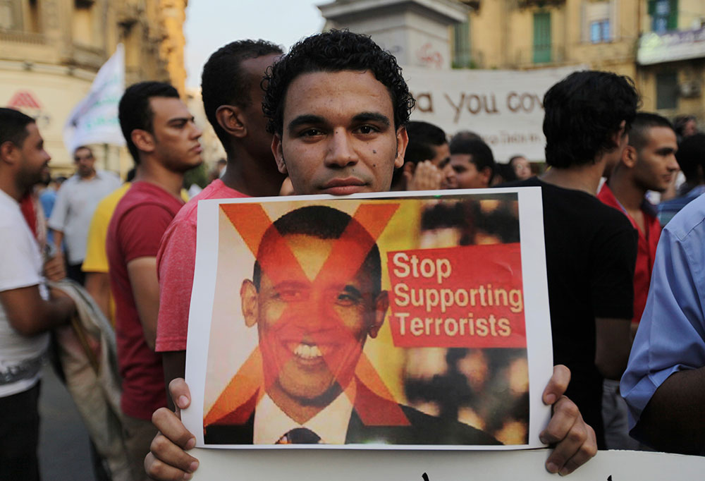 मिस्र के काहिरा में सीरिया पर यूएस हमले की संभावना के खिलाफ प्रदर्शन करते लोग।