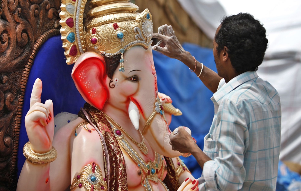 बेंगलुरु में गणेश चतुर्थी पर्व के मद्देनजर भगवान गणेश की मूर्ति को अंतिम रूप देता हुआ एक कलाकार।
