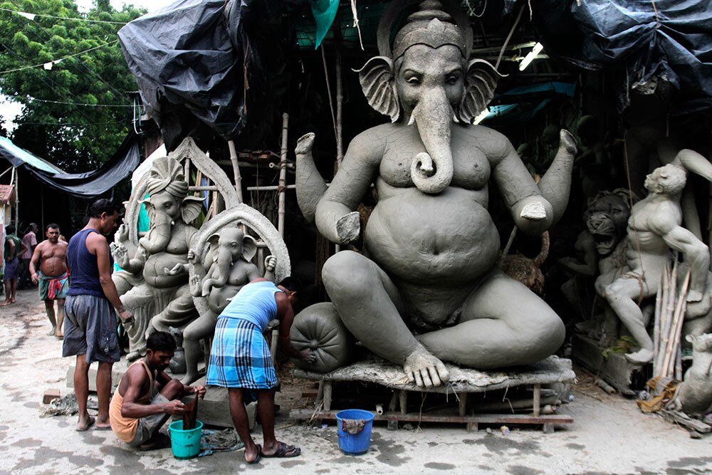 गणेश चतुर्दशी पर्व से पहले कोलकाता में भगवान गणेश की मूर्ति तैयार करते कलाकार।