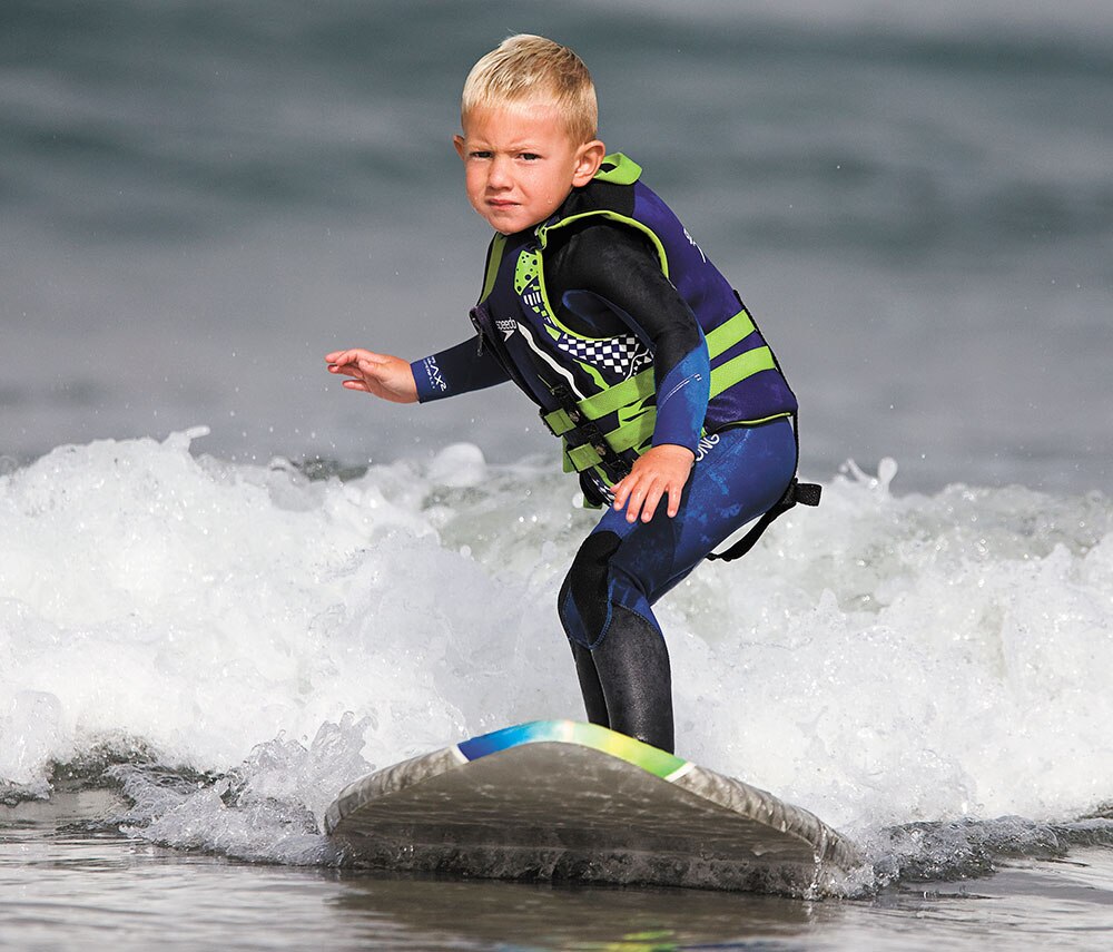 3 साल का बच्चा कैलिफ में समंदर में सर्फिंग करते हुए।