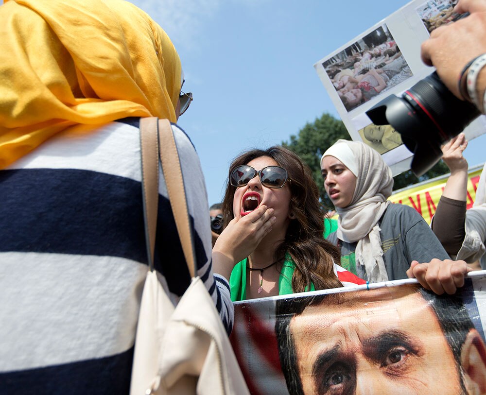 सीरिया में अमेरिकी रुख के खिलाफ विरोध प्रदर्शन करते लोग।