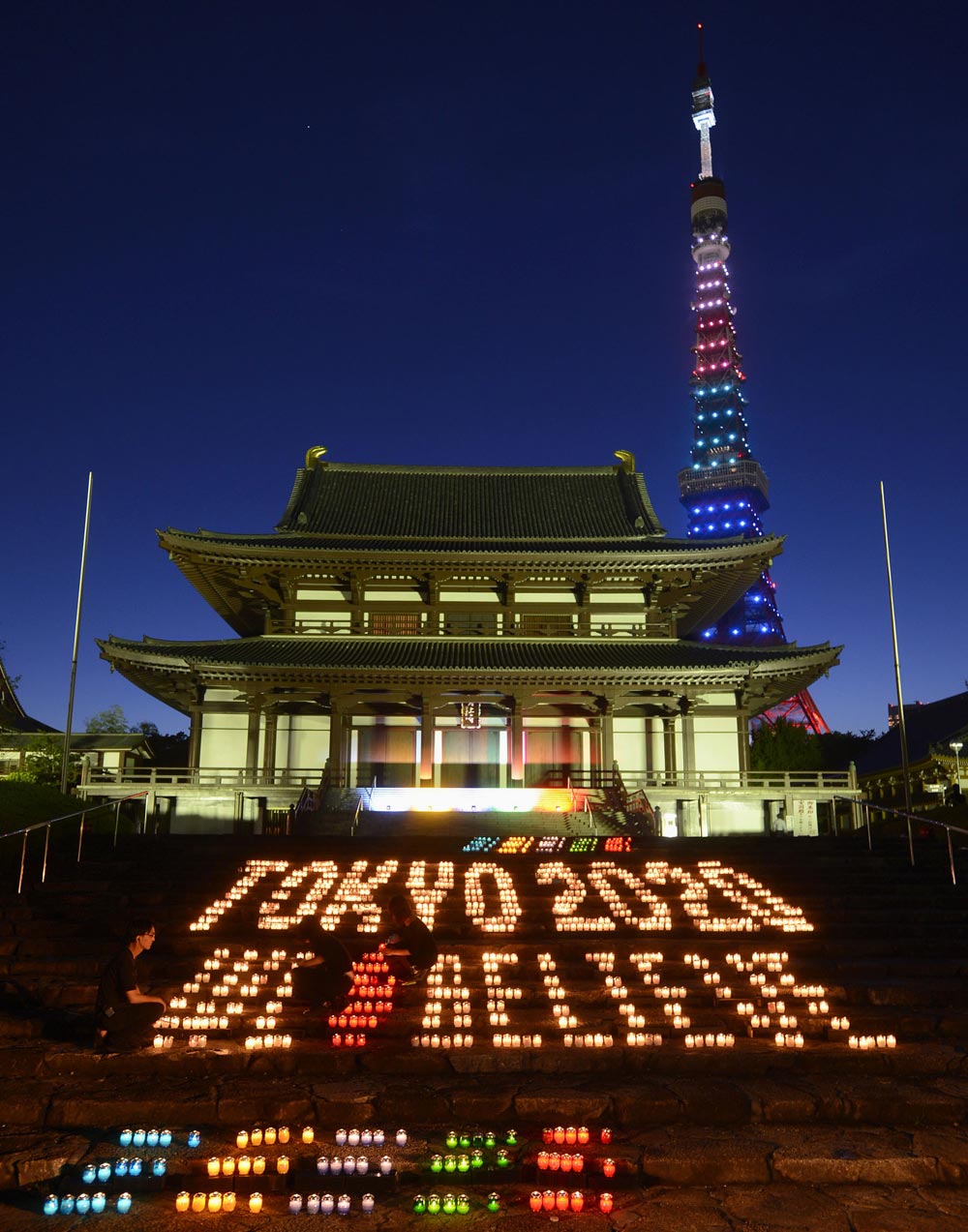 जापान: टोक्‍यो  में टोक्‍यो टावर के पीछे स्थित जेजोजी मंदिर के परिसर में ओलंपिक के रंग में मोमबर्ती को जलाया गया। इसमें यह संदेश दिया गया 'टोक्‍यो 2020 वी विलीव'।