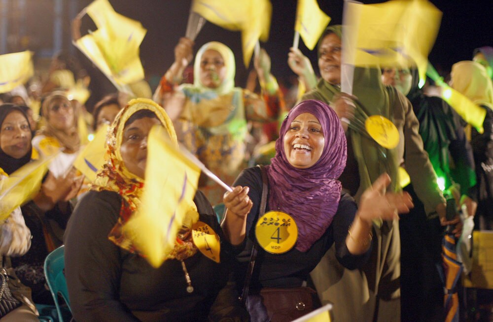 मालदीव में राष्‍ट्रपति चुनाव से पहले एक रैली के दौरान पूर्व राष्‍ट्रपति मोहम्‍मद नशीद के समर्थन में पार्टी का झंडा लहराते हुए महिला समर्थक।
