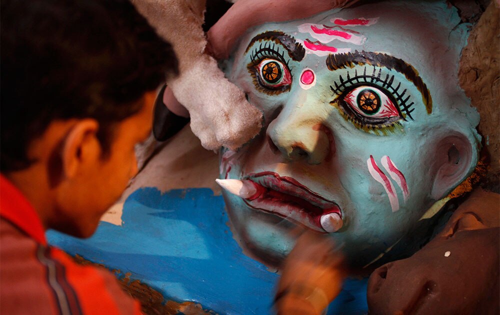 इलाहाबाद में राक्षस की प्रतिमा को रंगता एक चित्रकार।