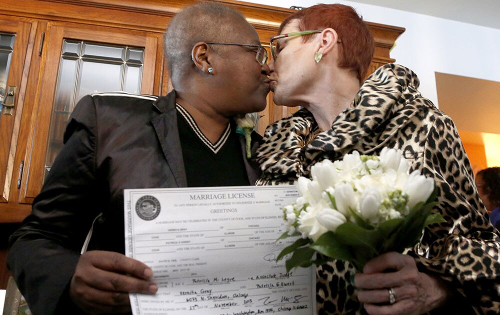 शिकागो में एक गे मैरिज करने के बाद एक दूसरे को चूमते हुए जोड़ा।