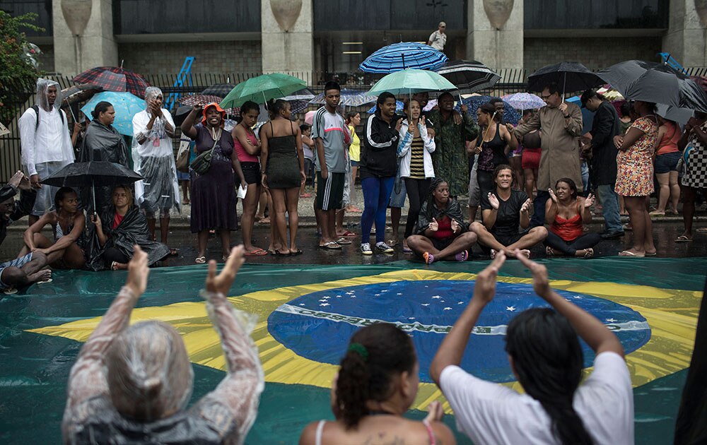 ब्राजील के रियो डी जेनेरियो में मेयर आफिस के सामने विरोध प्रदर्शन करते लोग।
