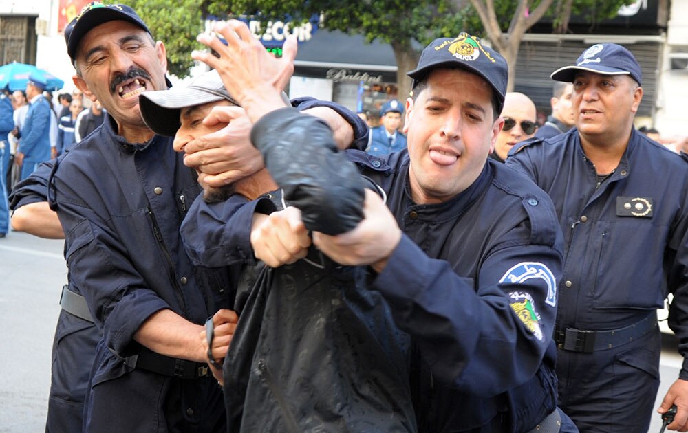 सरकार के खिलाफ विरोध-प्रदर्शन करते एक व्यक्ति को हिरासत में लेती अल्जीरियाई पुलिस।